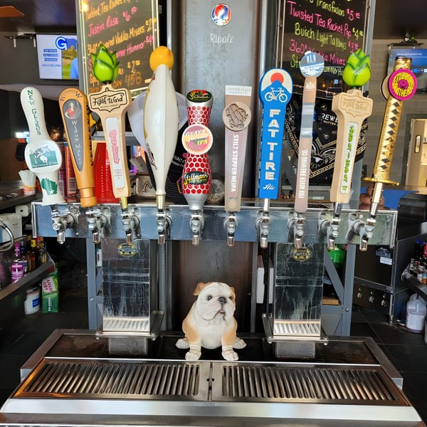 A row of diverse beer taps with a bulldog statue in front, at The Lodge on Main bar.